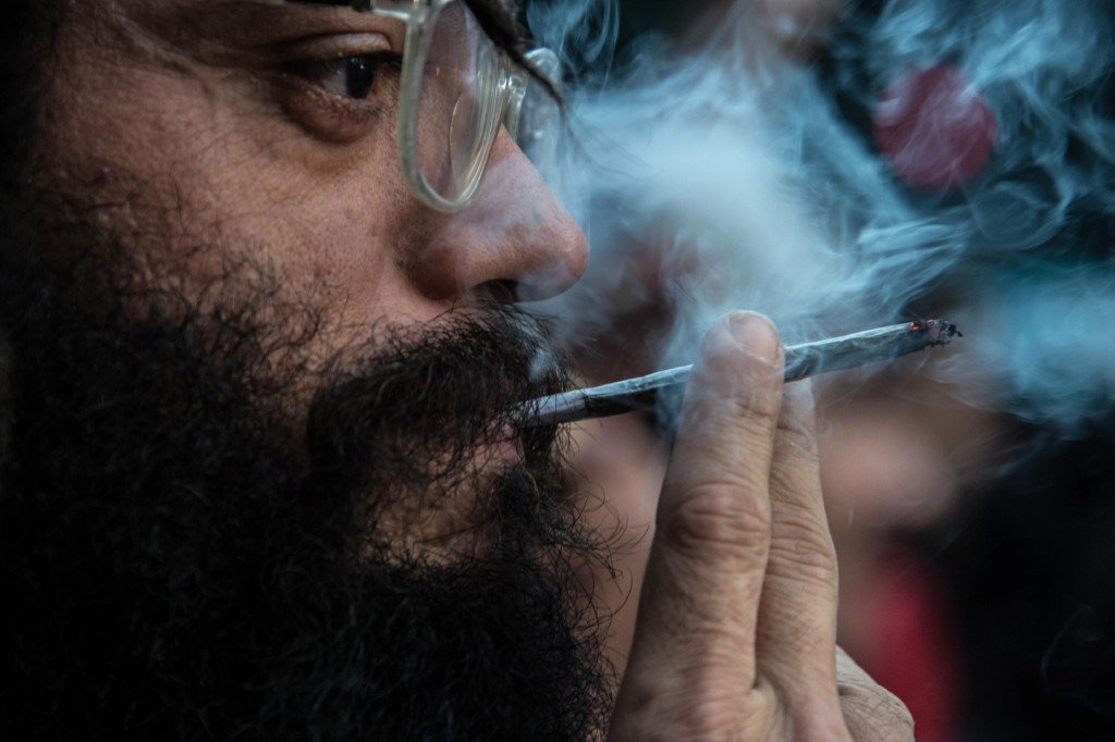 A demonstrator smokes a joint during a march calling for the legalization of marijuana along Paulista Avenue in Sao Paulo, Brazil, on May 14, 2016. / AFP / NELSON ALMEIDA        (Photo credit should read NELSON ALMEIDA/AFP/Getty Images)