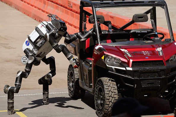 POMONA, CA - JUNE 05:  The Jet Propulsion Labs' Team RoboSimian 275-pound robot climbs out of a Polaris vehicle after driving through obsticles during the Defense Advanced Research Projects Agency (DARPA) Robotics Challenge at the Fairplex June 5, 2015 in Pomona, California. The . Organized by DARPA, the Pentagon's science research group, 24 teams from aorund the world are competing for $3.5 million in prize money that will be awarded to the robots that best respond to natural and man-made disasters.  (Photo by Chip Somodevilla/Getty Images)