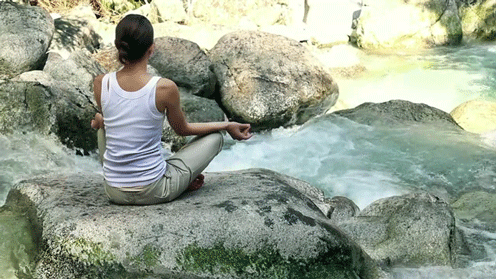 meditating-on-rock-overlooking-flowing-river-gif