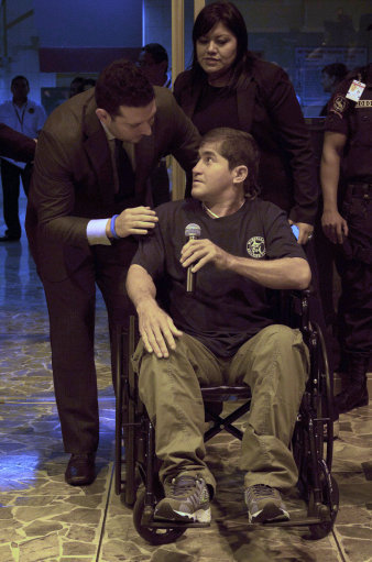 Jose Salvador Alvarenga holds a microphone intending to speak, after arriving at the airport in San Salvador, El Salvador, Tuesday, Feb. 11, 2014. Alvarenga was wheeled in a wheelchair before a crush of more than 100 mostly foreign journalists. But when handed the microphone, he held it in silence. The 37-year-old, who says he survived more than a year on a small boat drifting from Mexico across the Pacific Ocean to the Marshall Islands, arrived in his native El Salvador late Tuesday. (AP Photo/Salvador Melendez)