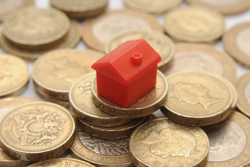 File photo dated 27/01/15 of a plastic model of a house on a pile of one pound coins, as most social housing tenants will see little or no direct benefit from Chancellor George Osborne's promised cut in rents, an economic think tank has said.