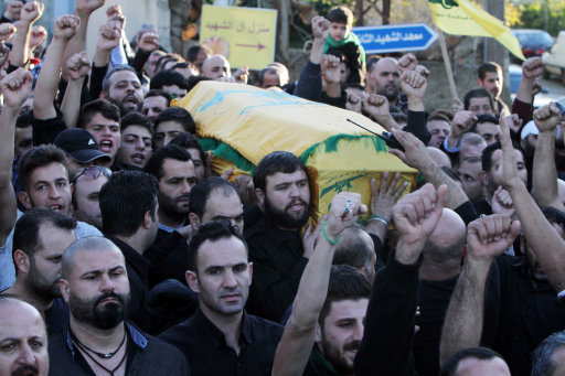 Relatives and friends carry the coffin of Hezbollah member Adel Termos, who was killed in Thursday's twin suicide bombings, as they chant slogans during his funeral procession in the southern Lebanese village of Tallousa, Lebanon, Friday, Nov. 13, 2015. Schools and universities across Lebanon are shut as the country mourns the victims of twin suicide bombings that struck a crowded neighborhood south of the capital. (AP Photo/Mohammed Zaatari)