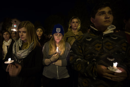 People hold candles during a vigil on Emory University's campus Monday, Nov. 16, 2015, in Atlanta, to honor the victims of Friday's attacks in Paris. Multiple attacks across Paris on Friday left scores dead and hundreds injured. (AP Photo/Branden Camp)
