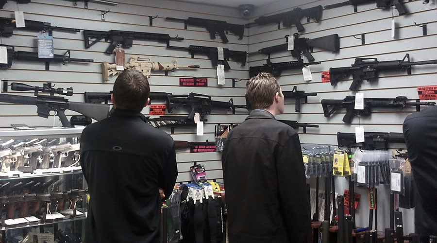 Customers view semi automatic guns on display at a gun shop in Los Angeles California