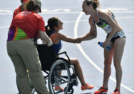 FILE - In this Aug. 16, 2016 file photo, New Zealand's Nikki Hamblin greets United States' Abbey D'Agostino, left, as she is helped from the track after competing in a women's 5000-meter heat during the athletics competitions of the 2016 Summer Olympics at the Olympic stadium in Rio de Janeiro, Brazil. (AP Photo/Martin Meissner, File)