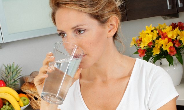 APDHN9 WOMAN IN KITCHEN DRINKING WATER